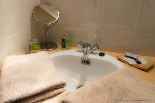 een badkamer met een wastafel en handdoeken bij Confluences in Walcourt