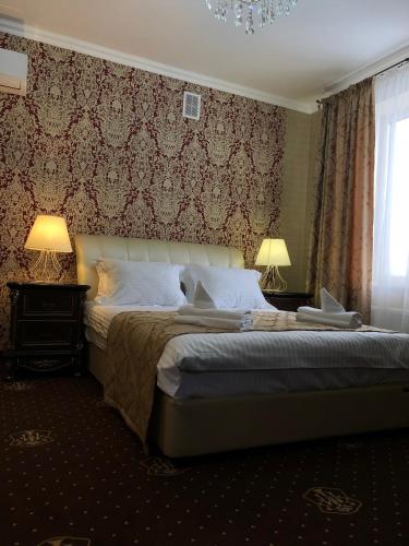 a bedroom with a bed and two lamps and a window at Hotel Boutique TOVMED in Vinnytsya