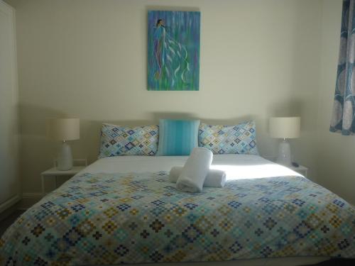 uma cama com um bicho de peluche em cima em Apartments On Grey em Glen Innes