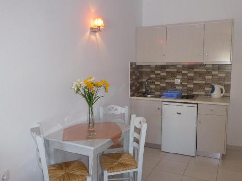 a kitchen with a table with a vase of flowers on it at Hotel Agnadi in Amorgos