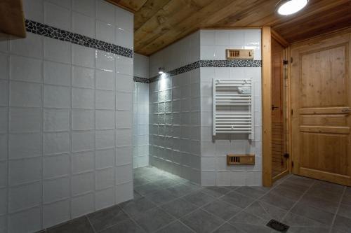 a bathroom with a walk in shower next to a door at Appartement Loretto in Les Houches