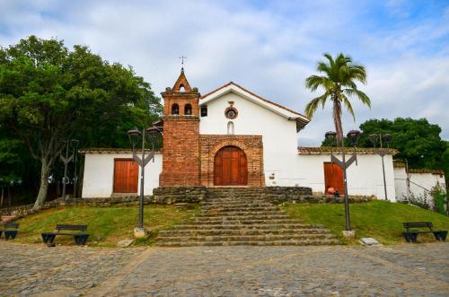 a white church with a clock tower and stairs at Magic Garden House in Cali