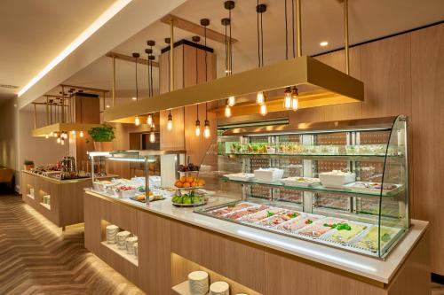 a restaurant with a display case filled with food at H+ Hotel Limes Thermen Aalen in Aalen