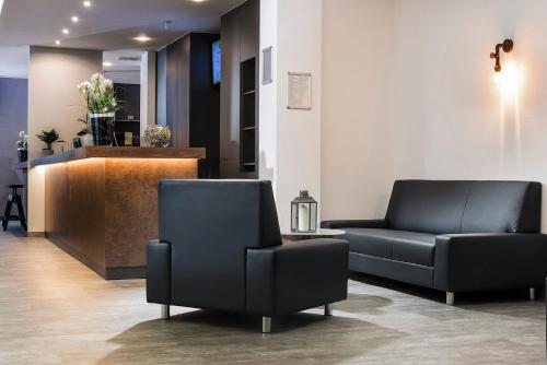 a waiting room with two chairs and a couch at ibis Styles Hotel Gelsenkirchen in Gelsenkirchen