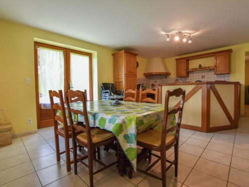 CazalsにあるHoliday home with private gardenのテーブル、椅子、テーブルクロス付きのキッチンが備わります。