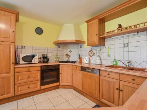 a kitchen with wooden cabinets and a sink at Holiday home with private garden in Cazals