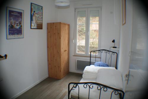 a small room with a bed and a window at Résidence du Château Lublin in La Bresse