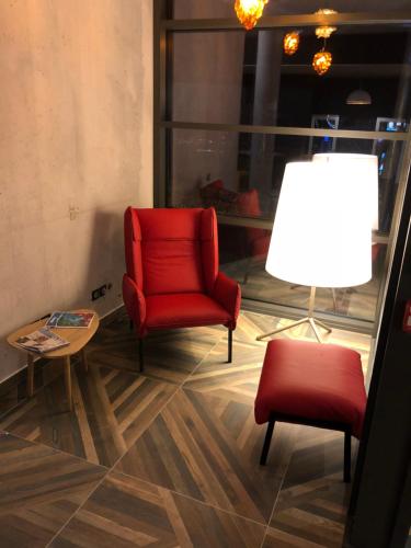 a room with two chairs and a table and a lamp at Ibis Budget Annecy sud-Poisy in Poisy