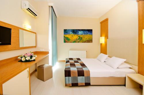 a hotel room with a bed and a tv at City's Hill Hotel in Kuşadası