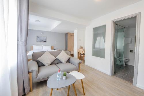 a living room with a couch and a bed at Common Inn Thao Dien in Ho Chi Minh City