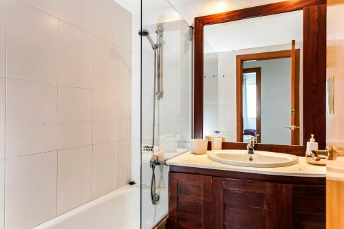 a bathroom with a sink and a shower with a mirror at 1410 - Mediterranean Forum Apartment in Barcelona