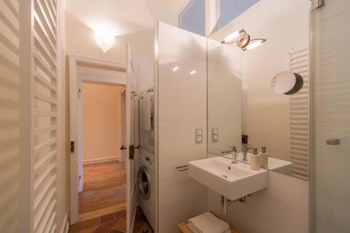 ein weißes Badezimmer mit einem Waschbecken und einem Spiegel in der Unterkunft Zweite Heimat Heidelberg in Heidelberg