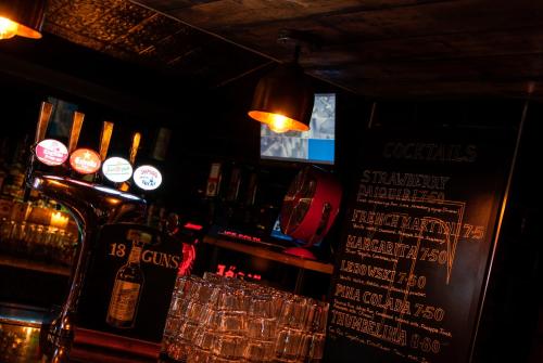 a bar with a counter with alcohol bottles and glasses at Tom Thumb Apartments in Liverpool