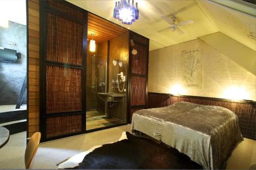 Un dormitorio con una cama y un baño con lavabo. en Hotel de Plataan Delft Centrum, en Delft