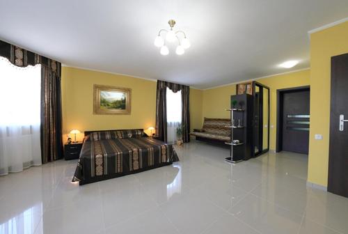 a large bedroom with a bed and yellow walls at Maxima in Kamianets-Podilskyi