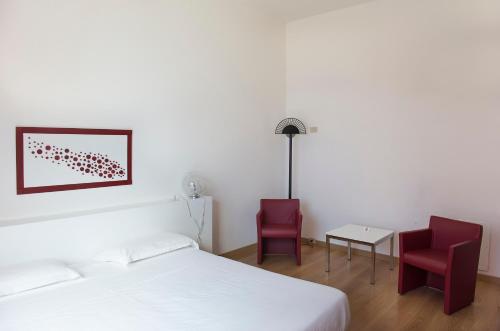 a bedroom with a bed and two red chairs at Park Hotel Residence in Crema