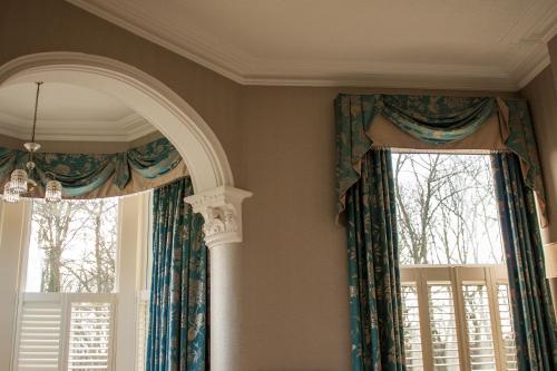 a room with two large windows with curtains at Ascot House in Harrogate