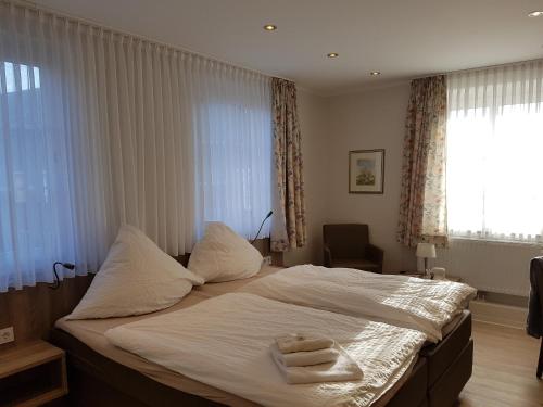 a bedroom with a bed with two towels on it at Hotel Pension Haus Pooth in Wesel