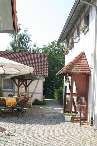 a patio with a table and umbrellas next to a building at Landhotel "Zum Nicolaner" in Großweitzschen