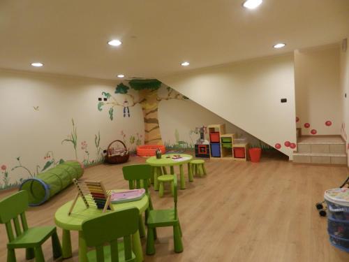 a room with tables and chairs and a tree painted on the wall at Residence Hotel Raggio Di Luce in Ponte di Legno