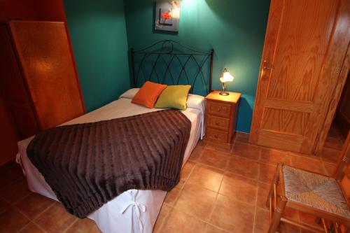 a bedroom with a bed and a green wall at Sierra De Monfrague in Torrejón el Rubio