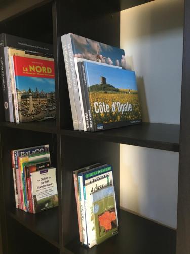 a book shelf with some books on it at Le Pave de la Croix Blanche in Le Pavé