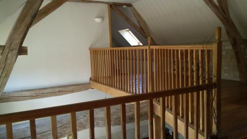 an attic room with a wooden staircase with a window at Gîte et chambres d'hôtes Le Chêne Billault in Pouant