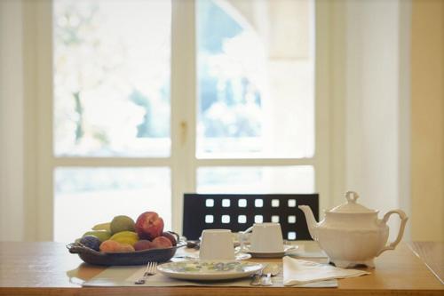 un tavolo con una ciotola di frutta e una teiera di Agrigturismo Monte Cicogna a Moniga