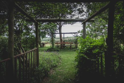 a garden with a wooden gate and a fence at Oribi Gorge Guest Farm in Glendale