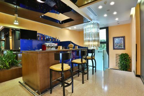 a bar in a restaurant with stools at a counter at Central Park Hotel Modena in Modena