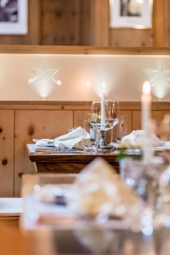 a table with a candle and a table set with dishes at Hotel Stern Chur in Chur