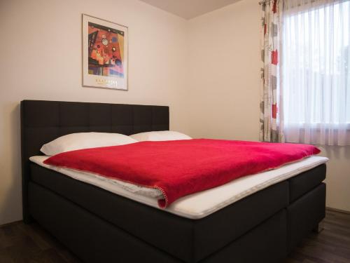 a bed with a red blanket on top of it at Ferien Haus bei Wien in Hagenbrunn