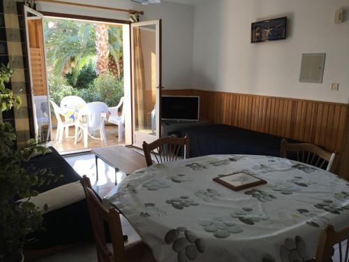 een woonkamer met een tafel en stoelen en een patio bij Residence la Catalane in Saint Cyprien Plage