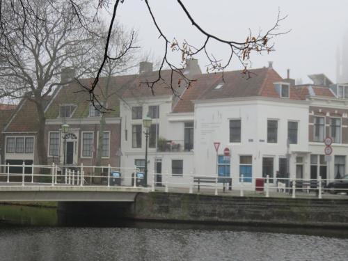 a white building next to a bridge over a river at Kromme weele 26 in Middelburg