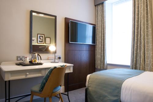 a hotel room with a desk and a bed at Balloch House by Innkeeper's Collection in Balloch