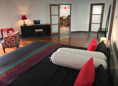 a bedroom with a large bed with red pillows at Villa Rizki Candidasa in Candidasa
