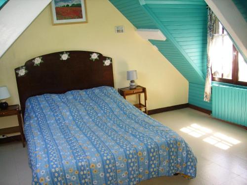 a bedroom with a bed with a blue comforter at Appartements Tonton Jo in Camaret-sur-Mer