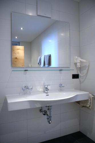 a white bathroom with a sink and a mirror at Laudinella - Apart in See