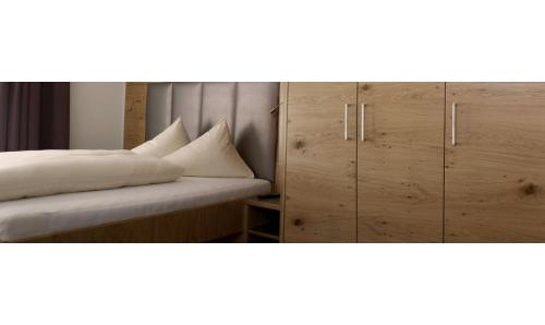 a bedroom with a bed and wooden cabinets at Laudinella - Apart in See
