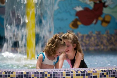 two young girls playing in the water at a fountain at Hotel Paganella in Andalo