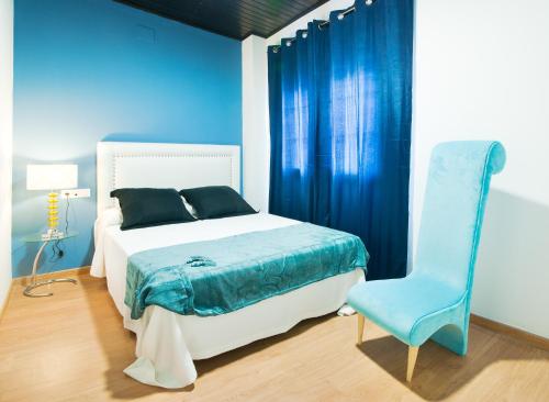 1 dormitorio azul con 1 cama y 1 silla azul en Narayana Casa Camilo, en El Cerro de Andévalo
