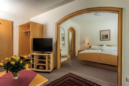 een hotelkamer met een bed en een televisie bij Hotel Pension Café Hasler in Bodman-Ludwigshafen