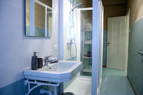 a white bathroom with a sink and a shower at B&B Quo Vadis Arena in Verona