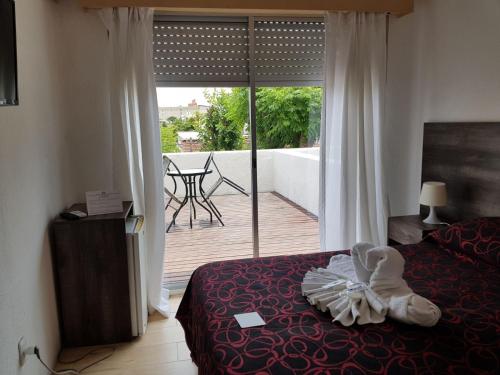 a bedroom with a bed and a balcony with a view at Hotel Palace Piriápolis in Piriápolis