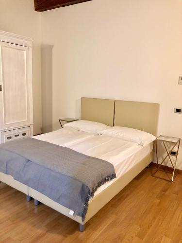 a bedroom with a large bed with white sheets at Pietra di Verona Residenza in Verona