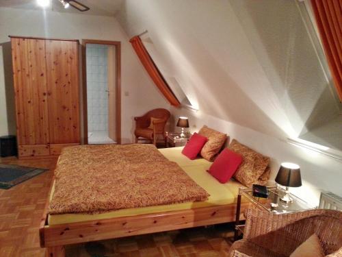 a bedroom with a bed with red pillows on it at Gasthof Altes Farmhaus und Apartment in Lienen