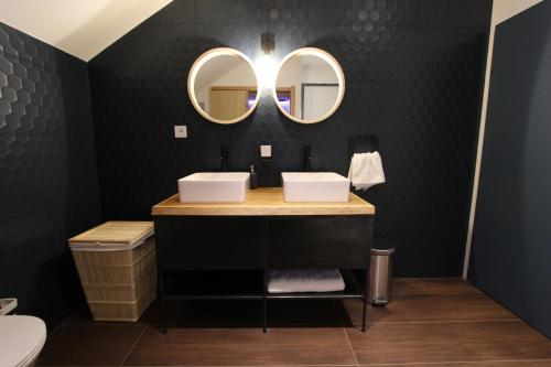 a bathroom with two sinks and two mirrors at La chouette d'or in Dijon