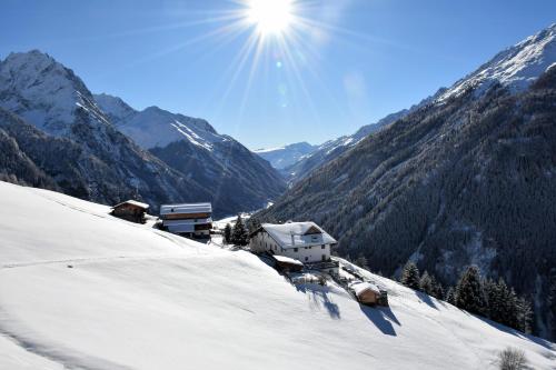 a snow covered mountain with the sun in the sky at Wiesenhof in Kaunerberg