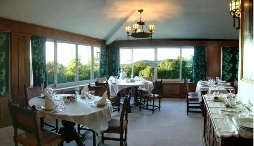 a dining room with tables and chairs and windows at Gran Hotel La Cumbre in La Cumbre
