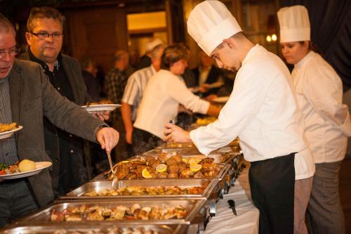 eine Gruppe von Köchen, die Speisen am Buffet zubereiten in der Unterkunft Hotel zum Schwan in Nachterstedt